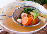 veggie soup broth in large bowl with scoop